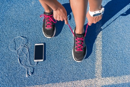 Runner woman tying running shoes laces getting ready for race on