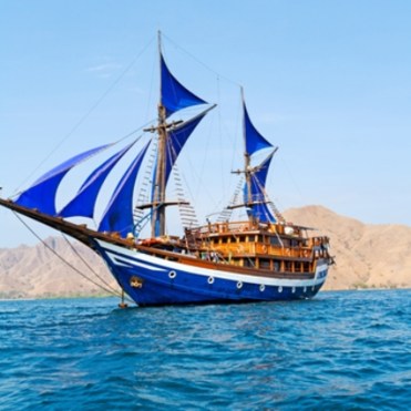Vintage Wooden Ship with Blue Sails